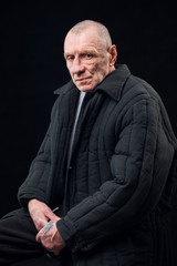 Portrait of a prisoner old man on a black background