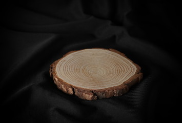 Cross section of tree trunk, stump on black fabric background