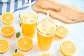 fresh orange Juice and oranges on the cutting board