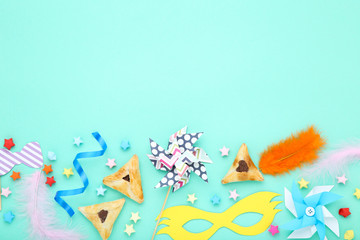 Purim holiday composition. Cookies with party supplies on blue background