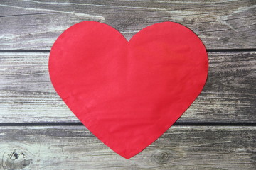 Red heart made of paper symbol of love on a background of wooden boards