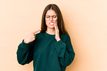 Fototapeta premium Young caucasian woman isolated on beige background having a strong teeth pain, molar ache.