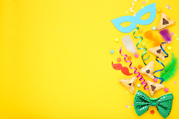 Purim holiday composition. Cookies with party supplies on yellow background - Powered by Adobe