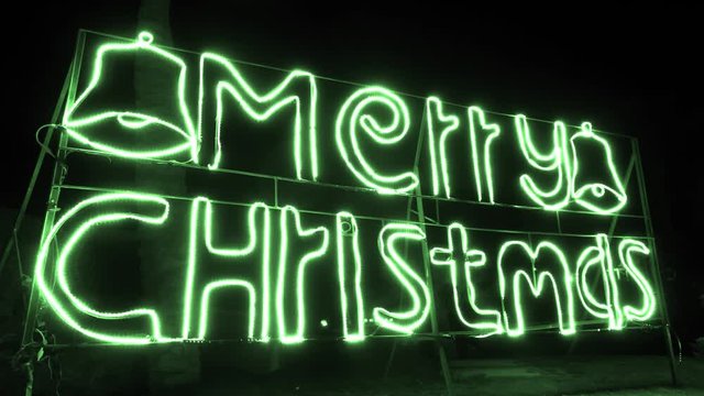 Green neon night signboard with message Merry Christmas