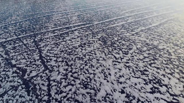4k video of frozen beautiful lake with snowy ornament on baikal lake in cold winter weather. Snow texture on ice lake filmed on quadrocopter in Siberia, Irkutsk. Perfect background blue frozen lake 
