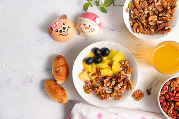 Healthy breakfast, fun food for children. The concept of healthy and natural food. Oatmeal with granola or granola, grapes, nuts and croissants, top view, selective focus.