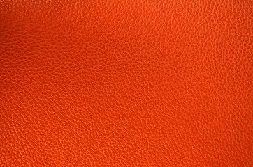 Leather texture close up. Orange fashionable background, top view. Stylish coral wallpaper with rough surface.