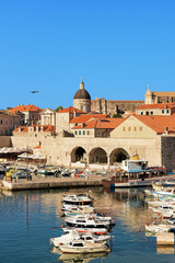 Fototapeta na wymiar Boats in Old port and Dubrovnik Cathedral