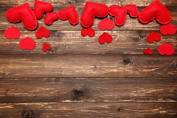 Red fabric hearts on brown wooden table