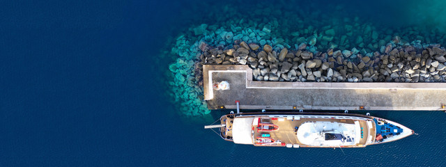 Aerial drone ultra wide photo of yacht docked in old port of Mykonos island, Cyclades, Greece