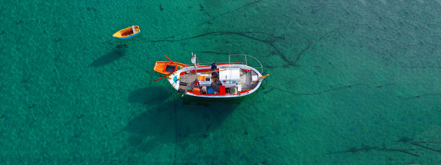 Aerial drone ultra wide photo of traditional fishing boat docked in old port of Mykonos island,...