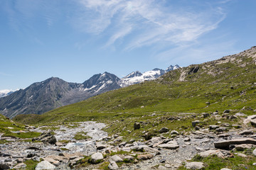 Glacier water spilling across mountain valley forming many streams.