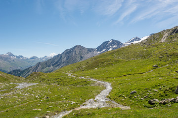 Obraz premium Glacier water spilling across mountain valley forming many streams.