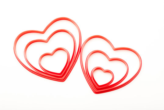 Pair of concentric red heart shapes nestled together on a white background