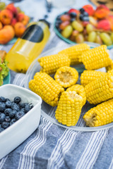 Summertime picnic setting on the grass with open picnic basket, fruit, salad and cherry pie