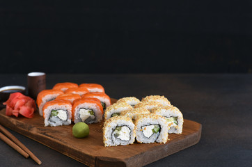 Different types of sushi served on a wooden board. Sushi menu. Japanese food.