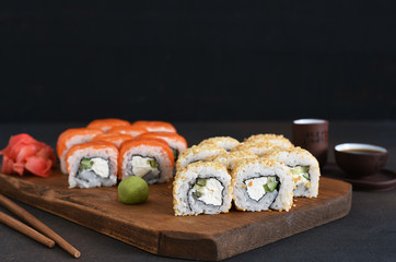 Different types of sushi served on a wooden board. Sushi menu. Japanese food.