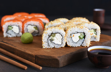Different types of sushi served on a wooden board. Sushi menu. Japanese food.