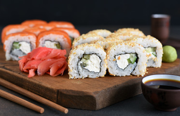 Different types of sushi served on a wooden board. Sushi menu. Japanese food.