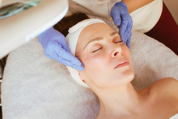 Fototapeta na wymiar A woman at the beautician, receiving a face massage.