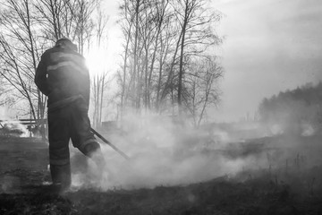 Raging forest spring fires. Burning dry grass, reed along lake. Grass is burning in meadow. Ecological catastrophy. Fire and smoke destroy all life. Firefighters extinguish Big fire. Lot of smok © Torkhov