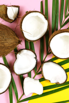 Healthy nutritious natural coconut with a vast range of dietary and cosmetic uses, shown here with coconut cut into pieces on modern colorful creative flat lay layout overhead. Vertical close up.