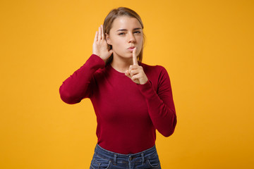 Curious young woman posing isolated on yellow orange background. People lifestyle concept. Mock up...
