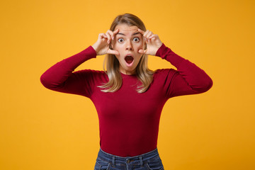 Shocked young blonde woman girl in casual clothes posing isolated on yellow orange wall background studio portrait. People lifestyle concept. Mock up copy space. Stretching eyelids keeping mouth open.