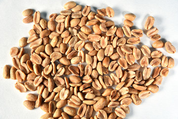 delicious and nutritious peanuts, peeled in a heart-shaped bowl with overhead view isolated on wooden table