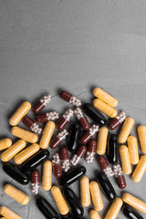 Different capsule pills on gray background, vertical frame