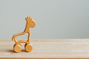 Wooden toy giraffe on wooden background
