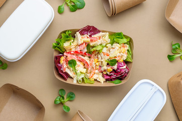 Vegetable salad in brown kraft paper food container on beige background