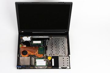 Repair  laptop, removed keyboard, hard disk drive, cd drive and  battery  on white background , visible orange CPU  fan with heat sink