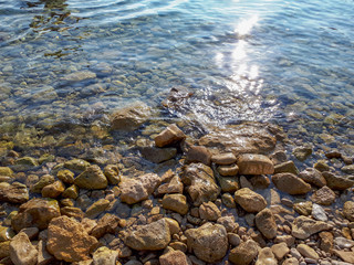 stones in turquoise sea water in Krk, Croatia