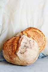 Homemade Freshly Baked Country Bread  made from wheat and whole grain flour on a gray-blue background. French Freshly baked bread. Slicing homemade bread 