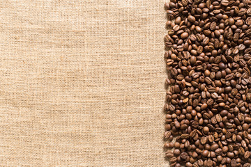 Fototapeta premium roasted coffee beans on sackcloth with space for text