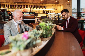  Two businessmen working together in modern cafe.