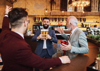  Three business people celebrating successfully done job at restaurant.