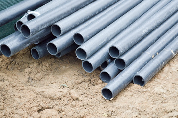 Large black plastic sewer plumbing pipes for the construction of water pipes or sewers at a construction site during the repair