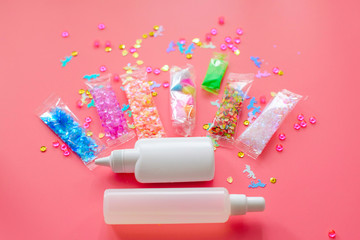 tools and ingredients for making slime - glue, thickener, sprinkles, charms