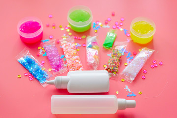 tools and ingredients for making slime - glue, thickener, sprinkles, charms