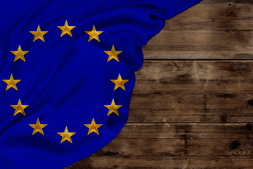 color European Union flag, symbol of united Europe, beautiful silk, background old wood, concept of tourism, economy, politics, emigration, independence day, copy space, template, horizontal