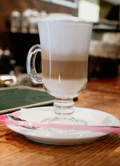 Glass cup of coffee latte on wooden table