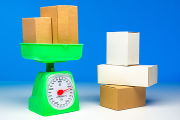 Weighing cardboard boxes. Boxes in line for weighing. Cardboard boxes stand on the scales. Concept - weighing goods before shipping. Concept - determination of weight. Logistic company