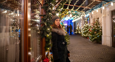 Young attractive girl in new year decorations on the street in winter Christmas holidays