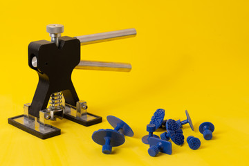 Repairing car dent after the accident by paintless dent repair puller and tools.