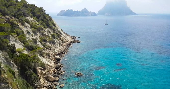 empty and beautiful Cala d'Hort beach, in summer very popular, sandy coast have a fantastic view of island of Es Vedra. With vessels on bay. Ibiza Island, Balearic Islands. Spain