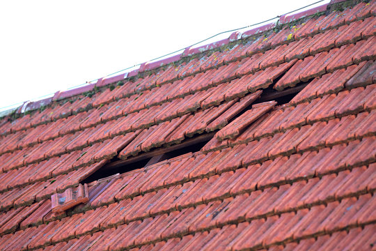 Dachschaden nach Sturm. Kaputte Dachziegel auf einem Haus Dach