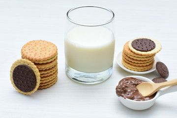 Chocolate cookies accompanied by glass of milk