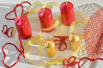 red and gold candles with ribbons and contours of hearts and butterflies